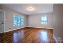 Open living room with gleaming hardwood floors, neutral paint, and multiple windows offering abundant natural light at 828 Williams St, Gastonia, NC 28052
