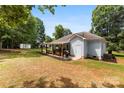 Spacious backyard featuring a covered patio with a grill, perfect for outdoor entertaining and relaxation at 8438 Henry Harris Rd, Fort Mill, SC 29707