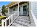 Inviting front porch with painted brick steps and white railings, complemented by hanging floral arrangements at 8438 Henry Harris Rd, Fort Mill, SC 29707