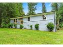 Charming one-story home with light blue painted brick, green lawn and mature trees at 10514 Harbor Dr, Charlotte, NC 28214