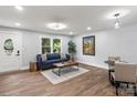 Open concept living room with wood floors, modern decor, a sofa and a dining area at 10514 Harbor Dr, Charlotte, NC 28214