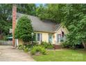 Inviting single-story home with mature trees, lush lawn and charming blue accents, creating a warm appeal at 111 Beacon Hills Dr, Gastonia, NC 28056