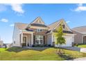 Attractive home featuring brick and siding accents, a covered entry, a well-kept lawn, and professional landscaping at 125 White Apple Way, Statesville, NC 28625