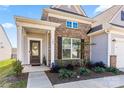 Inviting front porch with decorative door, brick accents, manicured landscaping, and a well-maintained walkway at 125 White Apple Way, Statesville, NC 28625