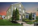 Charming two-story home featuring a welcoming front porch, lush green lawn, and mature trees at 12525 Druids Glen Dr, Pineville, NC 28134