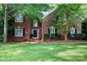 Two-story brick home featuring a well-maintained lawn and decorative shrubs enhancing curb appeal at 1587 Summit View Dr, Rock Hill, SC 29732