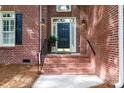 Inviting brick porch entrance with elegant black door and charming lantern-style sconces at 1587 Summit View Dr, Rock Hill, SC 29732