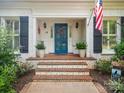 Inviting entrance with a blue door, brick steps, and lush landscaping with flowers at 2032 Greenbrook Pkwy, Matthews, NC 28104