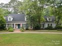 The front exterior boasts a lush lawn, brick steps, and a charming blue front door at 2032 Greenbrook Pkwy, Matthews, NC 28104