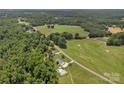 Beautiful aerial shot showcases a private estate with rolling green fields and tree-lined boundaries at 247 Helton Rd, Cherryville, NC 28021