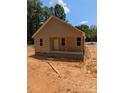 Cozy single-story home with neutral siding, showcasing a welcoming front porch and natural surroundings in a partially cleared lot at 2560 S Jake Alexander S Blvd, Salisbury, NC 28146