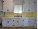 Classic kitchen with white cabinets and a contrasting yellow countertop at 309 Fannie Cir, Charlotte, NC 28205