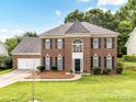 Beautiful brick home featuring a manicured lawn, dark shutters, and a convenient two-car garage at 3533 Weddington Ridge Ln, Matthews, NC 28105