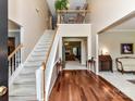 Elegant foyer showcasing hardwood floors, staircase, and a view of the living spaces beyond at 3533 Weddington Ridge Ln, Matthews, NC 28105