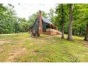 Quaint home featuring a brick chimney and cozy porch surrounded by lush greenery and a rustic tractor at 3547 Willowood Pond Dr, Rock Hill, SC 29730
