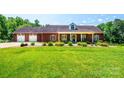 Beautiful brick home featuring an attached garage, manicured lawn, and welcoming front porch at 4010 Carlton Dr, Claremont, NC 28610