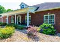 Inviting brick home with a charming front porch, perfect for enjoying the outdoors in comfort at 4010 Carlton Dr, Claremont, NC 28610