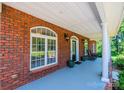 Covered front porch featuring brick columns, rocking chairs, and decorative touches with an inviting atmosphere at 4010 Carlton Dr, Claremont, NC 28610