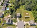 Aerial view of a neighborhood showcasing a home with a large backyard, pond, and play area at 4535 Falls Lake Sw Dr, Concord, NC 28025
