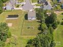 Aerial view of backyard with pond, play area, and privacy fence at 4535 Falls Lake Sw Dr, Concord, NC 28025