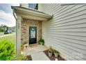 Close-up of a front porch with stone accents, decorative plants, and a welcoming front door at 505 Silers Bald Dr, Fort Mill, SC 29715