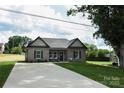 Well-maintained brick home with black accents, landscaped yard, and extended driveway at 604 E Ohio Ave, Bessemer City, NC 28016