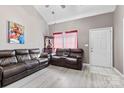 Spacious living room with vaulted ceilings, wood-look floors, and comfortable leather sofas at 6113 Windsor Gate Ln # 6113, Charlotte, NC 28215