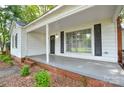 Inviting covered porch with large window and classic black shutters at 636 Forest Nw St, Concord, NC 28025