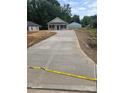 Newly poured concrete driveway leads to a charming single-story home, surrounded by green landscaping at 812 Generation Ln, Clover, SC 29710