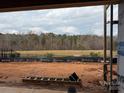 Backyard during construction, showing an open space with a distant view of bare trees and an overcast sky at 9662 Liberty Hill Dr, Mint Hill, NC 28227