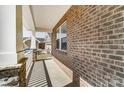 Side porch showing brickwork, white columns, and a view of the neighboring house with a white picket fence at 9662 Liberty Hill Dr, Mint Hill, NC 28227