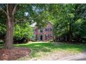 Beautiful brick home with large front lawn and a canopy of mature trees at 10408 Hadleigh Pl, Charlotte, NC 28210