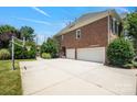 Exterior with a basketball hoop, large driveway, and three-car garage offers ample parking and recreational space at 11335 Wescott Hill Dr, Huntersville, NC 28078