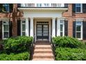 Inviting front entrance with brick steps, manicured shrubs, and an elegant double door with glass panels at 11335 Wescott Hill Dr, Huntersville, NC 28078