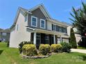 Charming two-story home featuring professional landscaping, a manicured lawn, and a welcoming facade at 11511 Wilson Mill Ln, Pineville, NC 28134