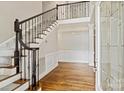 Elegant foyer featuring hardwood floors, staircase with wrought iron railing, and decorative wainscoting at 121 Canterbury Xing, Fort Mill, SC 29708