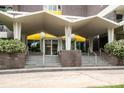 Building entrance with a covered portico, brick accents, and stairs leading to glass doors at 1300 Reece Rd # 206, Charlotte, NC 28209