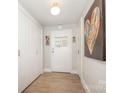 Hallway featuring wood floors, white walls, modern light fixture and a heart-themed art piece at 1300 Reece Rd # 206, Charlotte, NC 28209