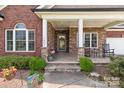 Inviting front porch with stone columns and accents, featuring a seating area, ideal for relaxing at 1302 Devonmere Pl, Salisbury, NC 28144