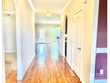 Long hallway featuring hardwood floors, archways, neutral paint, and multiple doorways, offering connectivity at 1302 Devonmere Pl, Salisbury, NC 28144