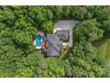 Aerial view of a secluded home surrounded by lush trees, pool, and multi-car garage at 1317 Longleaf Ct, Matthews, NC 28104