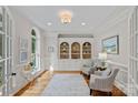 Bright living room featuring custom built-ins, wainscoting, hardwood floor, and arched window at 1317 Longleaf Ct, Matthews, NC 28104