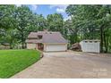 Exterior of a two-story home with a two-car garage, long driveway, shed, and manicured lawn at 138 Ardmore Pl, Mooresville, NC 28117