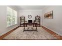 Bright office space with large window, hardwood floors, stylish rug, and two bookcases at 14746 Greenpoint Ln, Huntersville, NC 28078