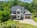 Aerial view of a modern farmhouse with manicured lawn, mature trees, and inviting curb appeal at 1543 Withers Dr, Denver, NC 28037