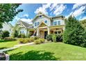 Inviting two-story home showcasing a covered porch and lush green lawn at 1908 Masons Bend Dr, Fort Mill, SC 29708