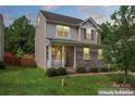 Charming two-story home with stone accents, a cozy front porch, and a well-maintained lawn at 231 Anvil Draw Pl, Rock Hill, SC 29730