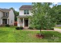 Charming two-story home with stone accents, a cozy front porch, and a well-maintained lawn at 231 Anvil Draw Pl, Rock Hill, SC 29730
