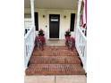 Welcoming front porch with brick steps, white railings, potted flowers, and a black front door at 250 Wesley Amaker Rd, York, SC 29745