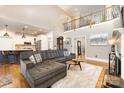 Open-concept living area with a large sectional sofa, hardwood floors, and a staircase at 254 Charter Se Ct, Concord, NC 28025